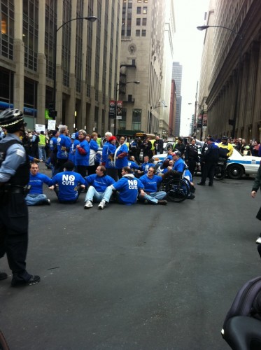 a group of people wearing blue blocked the street at Jackson and LaSalle. Also in the photo, a police officer watches
