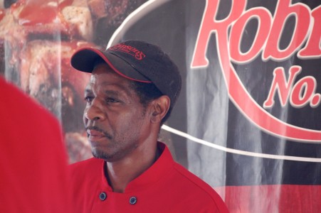 A worker at Robinson's takes a break from serving up the restaurant's famous barbecue at the preview to the Taste of Chicago in downtown Chicago on Wednesday.